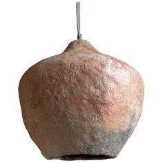 a rock hanging from a hook on a white background