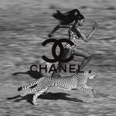 a woman running next to a cheetah on top of the word chanel