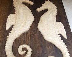 two white seahorses sitting on top of a wooden table