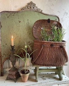 a wicker basket sitting on top of a table next to a candle and potted plant