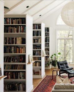 a living room filled with lots of books and furniture