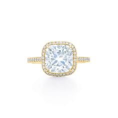 an engagement ring with a cushion cut diamond surrounded by round brilliant pave halos