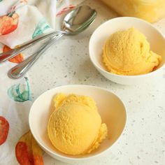 two white bowls filled with yellow ice cream