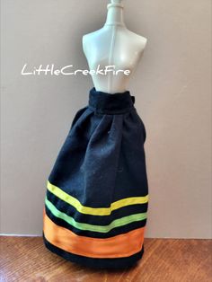 a mannequin wearing a black skirt with yellow, green, and orange stripes