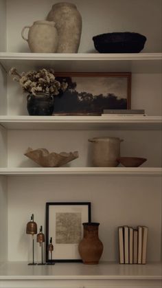 shelves with vases, books and pictures on them