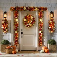 a front door decorated for fall with pumpkins and wreaths on the side wall