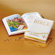 an open bible on a table next to a rosary