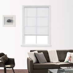 a living room with a couch, chair and coffee table in front of a window