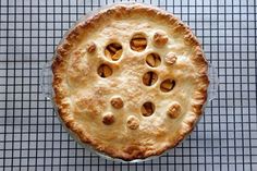 a pie sitting on top of a metal pan next to a wire cooling grate