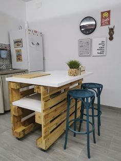 three stools sit at the center of a kitchen island made out of pallets