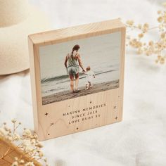 a wooden photo frame with a man and his dog on the beach