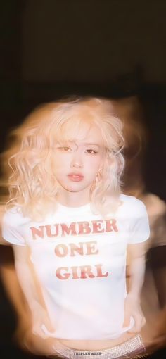 a woman with blonde hair is wearing a white shirt and has the number one girl on it