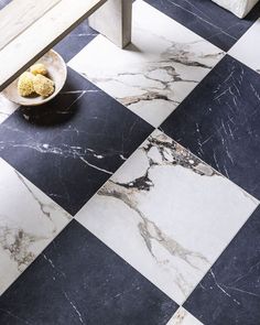 a black and white checkerboard floor with a bowl of food on the side