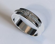 a white gold wedding ring with three princess cut diamonds on the side, set in 18k white gold