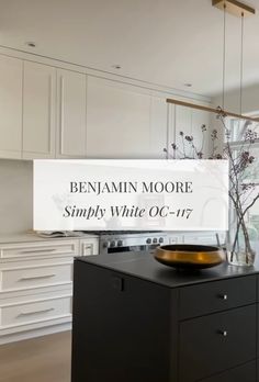 a kitchen with white cabinets and black countertops has a sign that says, benjamin moore simply white oc - 077