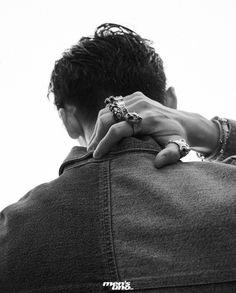 black and white photograph of a man with his hand on the back of his jacket