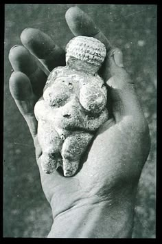 a hand holding some kind of rock in it's palm