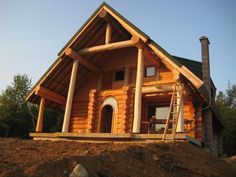 a log cabin sits on top of a hill with stairs leading up to the front door