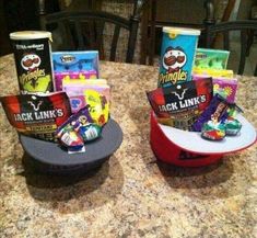 two hats sitting on top of a table filled with snacks and candy bar wrappers