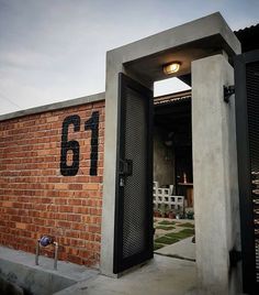 an open door to a brick building with the number 61 on it's side