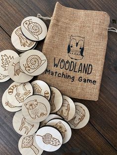 wooden buttons with the words woodland matching game on them next to a burlock bag