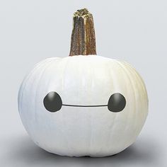 a white pumpkin with an emoticive face drawn on it's front and side