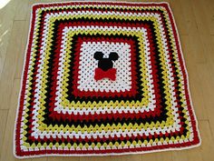 a crocheted square with a dog's face on it is sitting on the floor