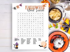 a printable halloween word search is shown on a table with candy and candies