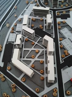 a model of an airport with donuts on the ground and buildings in the background