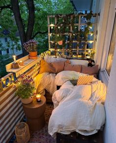 a bed sitting on top of a wooden floor next to a window filled with plants