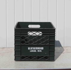 a large black crate sitting on top of a cement floor next to a white wall