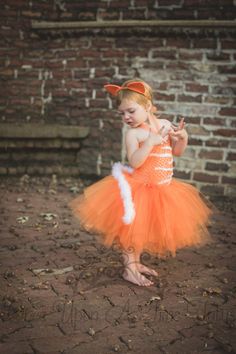 "Orange White Cat Tutu Dress An unlined orange crochet tutu top embellished with white felt detail, a full orange tutu, and a marabou feather \"tail\" attached to the back. Cat ears can be added through the drop down menu. Sizes and Lengths: (Tail will be longer) 0-6 Months Length - 6 Inches 6- 12 Months Length - 7 Inches 12M - 2T 8 inch length 3T - 4T 10 inch length 5 - 6 12 inch length 7 - 8 14 inch length 8/10 14 inch length 10 - 12 14 inch length 12 - 14 14 inch length Perfect for gift givin Toddler Cat Costume Diy, Orange Cat Costume, Toddler Cat Costume, Costume Baby Girl, Cat Costume Kids, Cat Costume Diy, Tutu Top, Halloween Costume Kids, Crochet Tutu