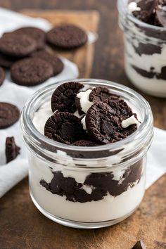 two jars filled with cookies and cream on top of a wooden table