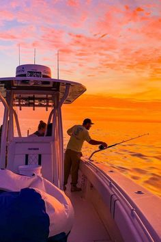 two men on a boat fishing at sunset