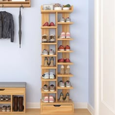 there are many pairs of shoes on the shelves in this room with blue walls and wooden flooring