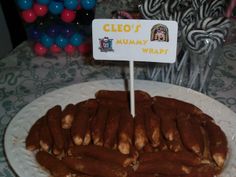 a white plate topped with chocolate covered pretzels and a sign that says cleo's hummy wrap