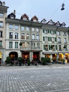 the building has many windows and lights on it's sides, along with an outdoor seating area