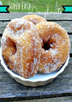 two sugar covered doughnuts in a white bowl on a wooden table with the words super easy doughnuts