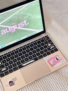 an open laptop computer sitting on top of a bed