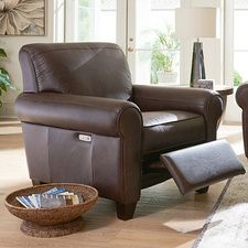 a brown recliner chair sitting in a living room next to a footstool