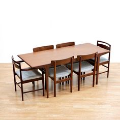 **Please Note: SHIPPING IS NOT FREE. Please read entire description.** This stunning dining table and set of six dining chairs were designed by John Herbert for A. Younger Ltd during the 1960S. Produced in afromosia wood, with gray freshly upholstered seats and beautifully shaped back rests. The table has wonderful minimalist design and quality construction, the contrasting woods and table shape make this a real statement piece. DIMENSIONS: TABLE -  72" wide x 31" deep x 29" high REGULAR CHAIRS - 19.5" wide x 18" deep x 31" high CARVER CHAIRS - 21.5" wide x 18" deep x 31.5" high CONDITION: This fantastic dining set in excellent vintage condition with new upholstery to the chairs. Please study the pictures carefully for a more accurate depiction and please get in touch if you have any quest Mid Century Modern Dining Table, Minimalist Dining Table, Midcentury Modern Dining Table, Mid Century Dining Table, Modernist Furniture, Carver Chair, Dining Table Wood, Canoga Park, British Furniture