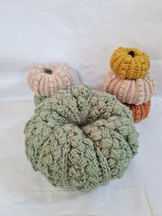 three crocheted pumpkins sitting next to each other