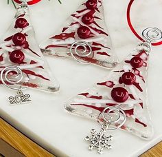 three glass ornaments with red and white icing on them sitting on a counter top