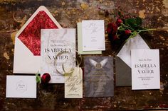 the wedding stationery is laid out on top of an old piece of wood with roses