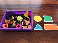 a purple container filled with lots of different items next to cut out shapes and numbers