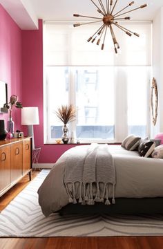 a bedroom with pink walls and wooden floors