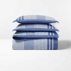 three blue and white striped pillows stacked on top of each other