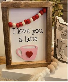 there is a sign that says i love you a latte and a cup with a heart on it