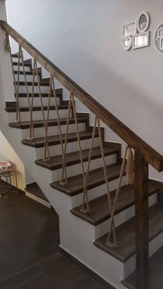 a stair case with rope on the bottom and handrails, along with a clock