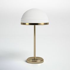 a table lamp with a white shade on it's top and a gold base